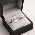 Silver ring with diamonds in an open jewelry box on a light gray background