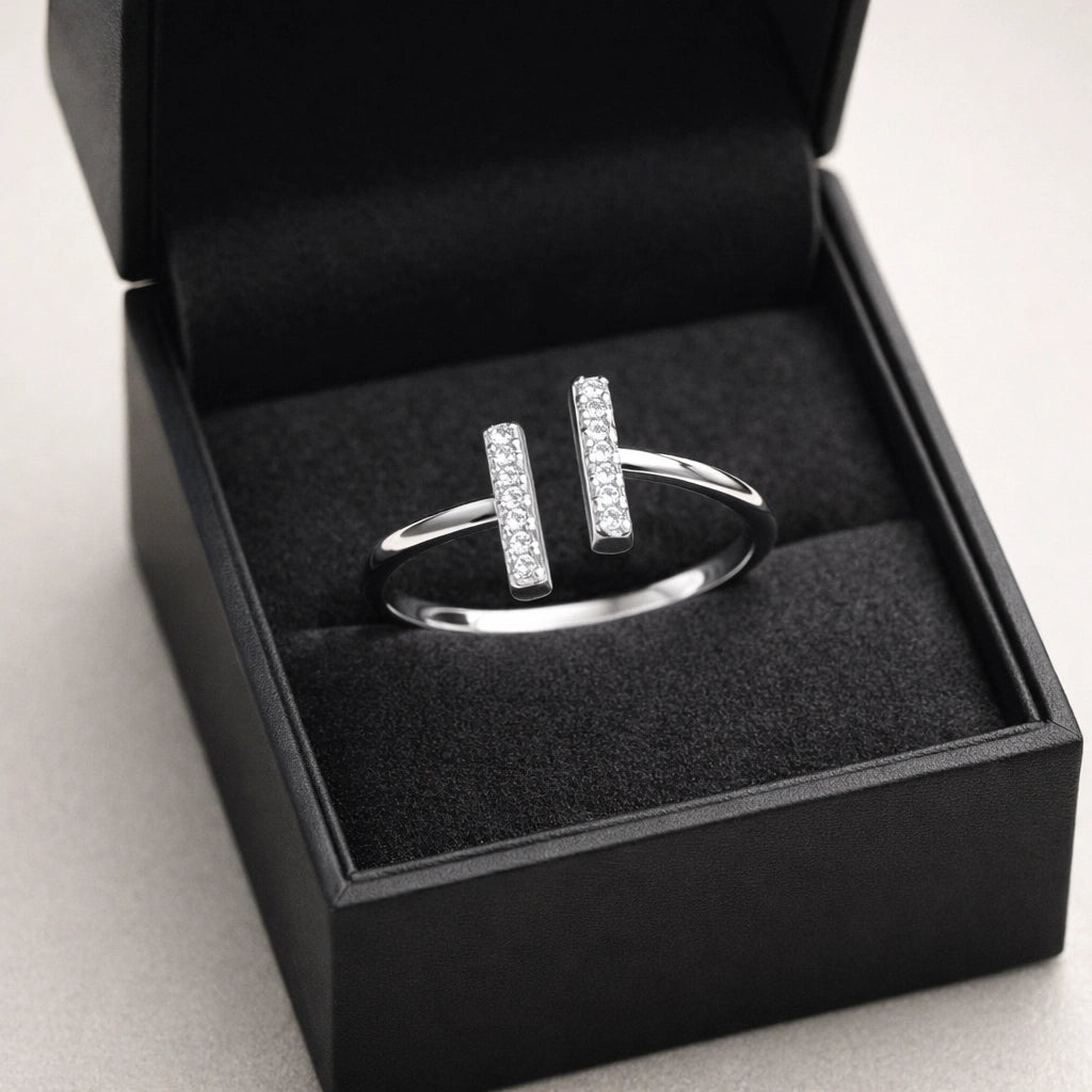 Silver ring with diamonds in a black jewelry box on a light gray background