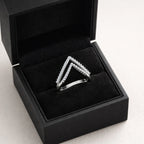Silver triangle-shaped ring in a black jewelry box on a light gray background