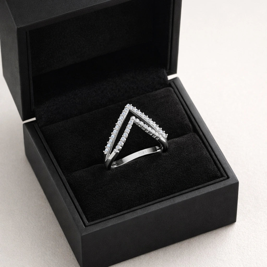 Silver triangle-shaped ring in a black jewelry box on a light gray background