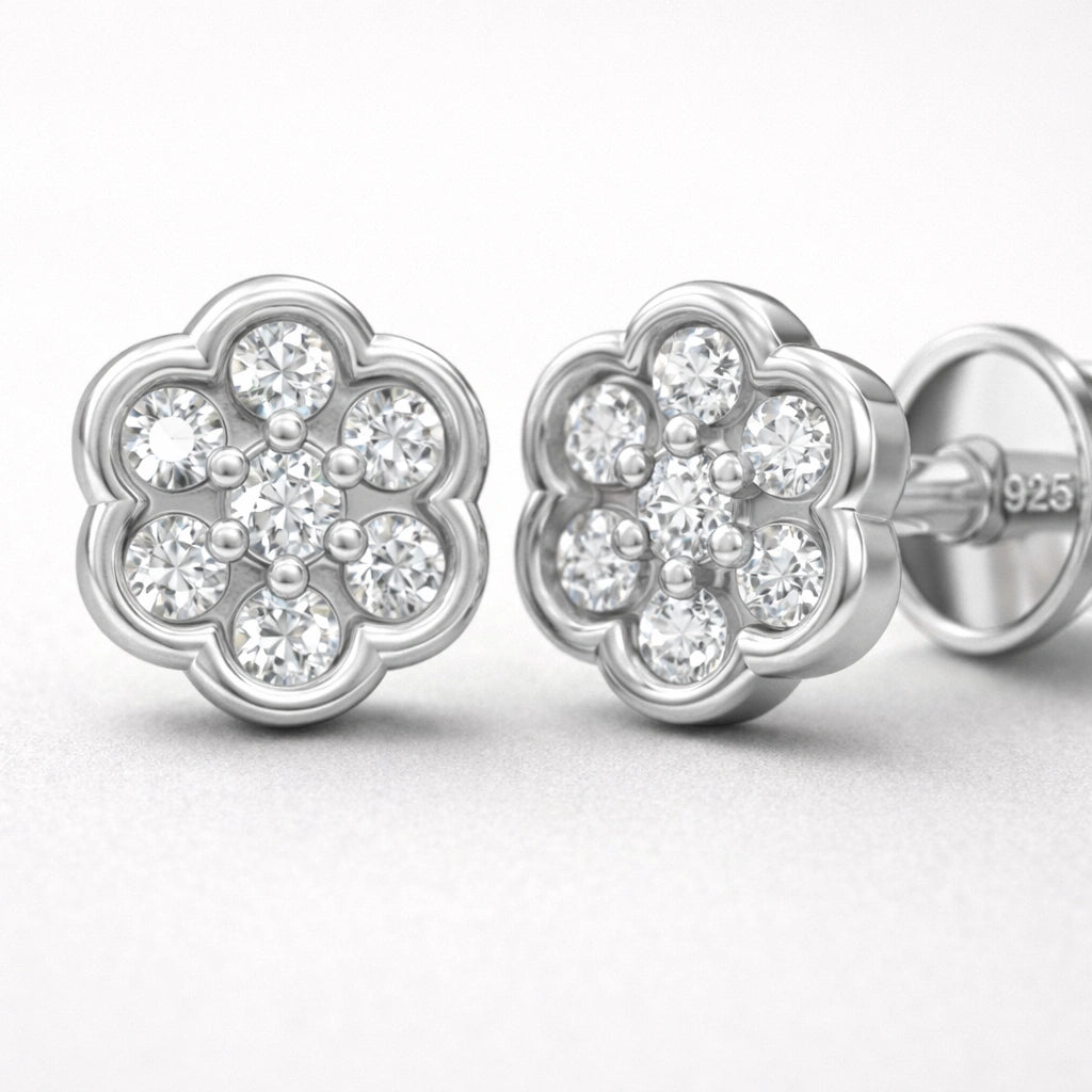 Silver flower-shaped earrings with clear gemstones on a white background