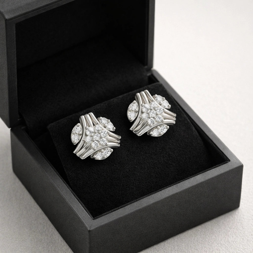 Pair of silver cufflinks in an open black box on a light gray background