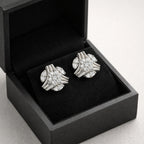 Pair of silver cufflinks in an open black box on a light gray background