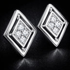 Pair of silver square-shaped earrings with clear gemstones on a dark background