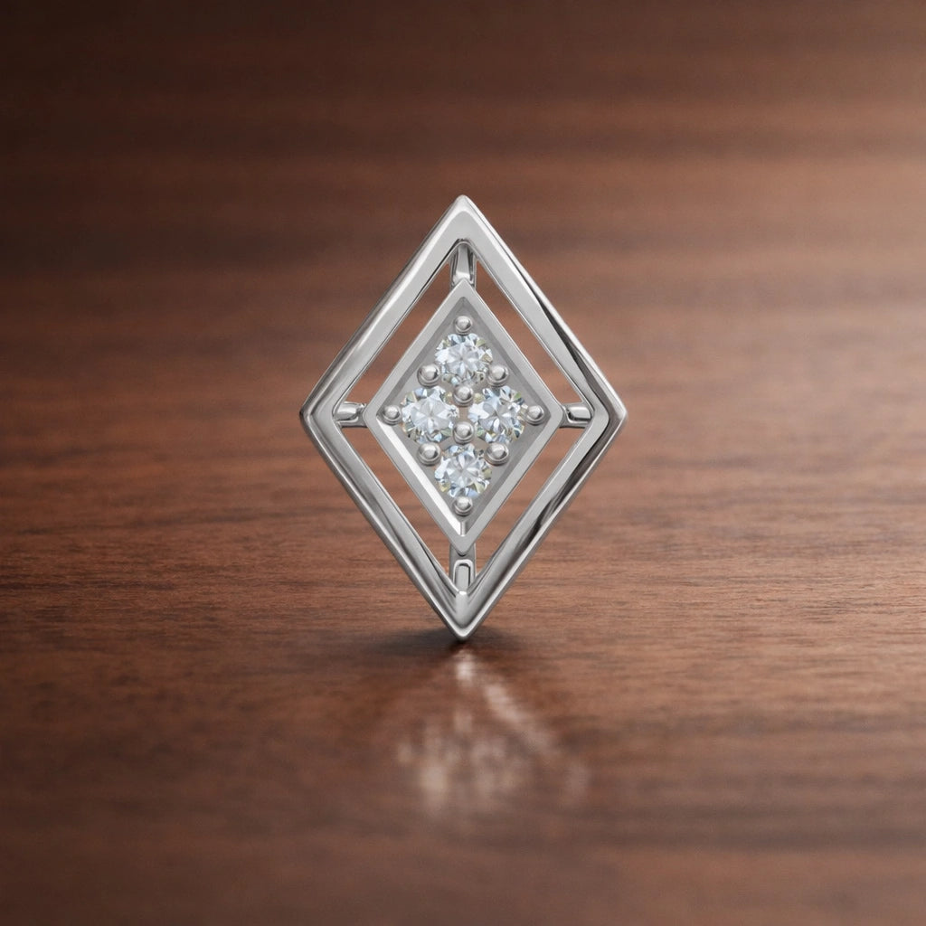 Silver diamond-shaped earring with embedded stones on a wooden surface