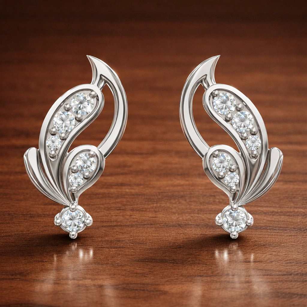 Pair of silver earrings with diamond accents on a wooden surface