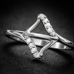 Silver ring with diamond accents on a dark background