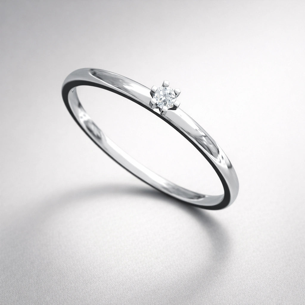 Silver ring with a small diamond on a light gray background