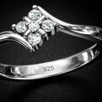 Silver ring with diamond-like stones on a dark background