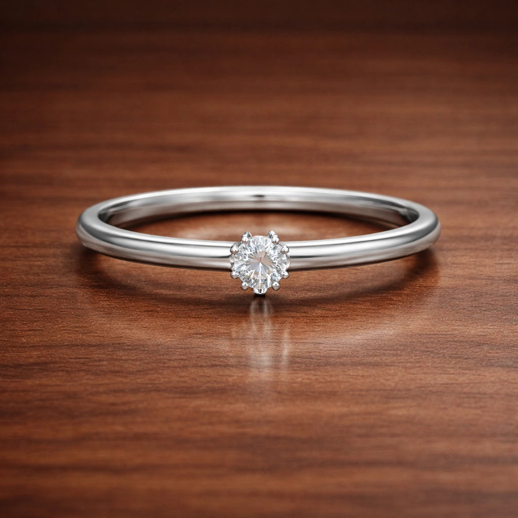 Silver ring with a diamond on a wooden surface