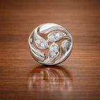 Silver brooch with gemstones on a wooden surface