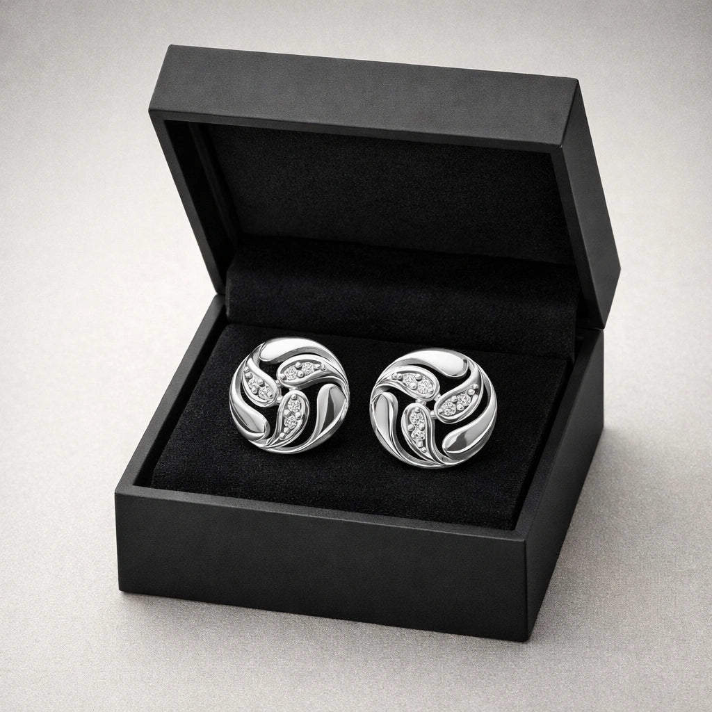 Silver cufflinks with gemstones in a black box on a light gray background