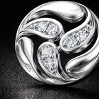 Silver ring with diamond accents on a dark background