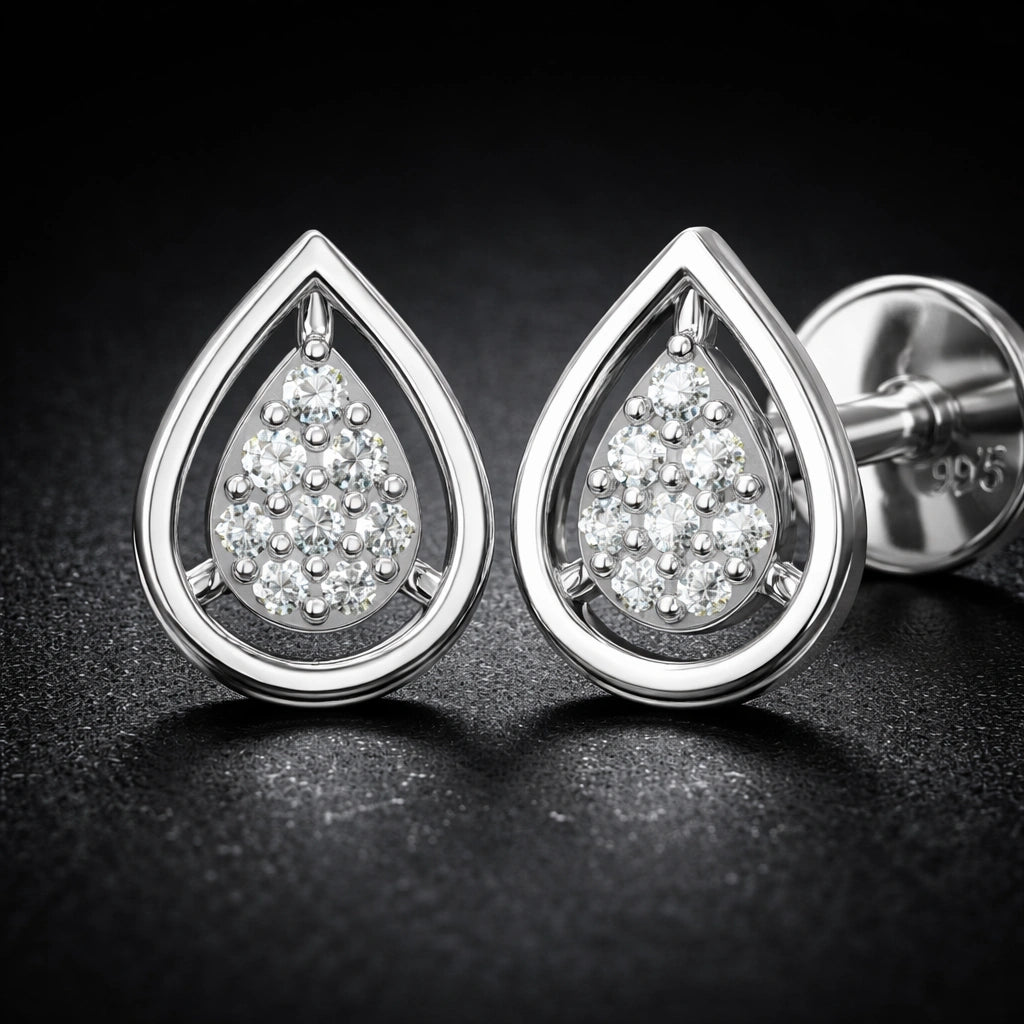 Teardrop-shaped silver earrings with clear gemstones on a dark background