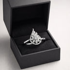 Silver leaf-shaped ring in a black jewelry box on a light gray background