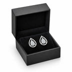 Teardrop-shaped silver earrings in a black jewelry box on a white background