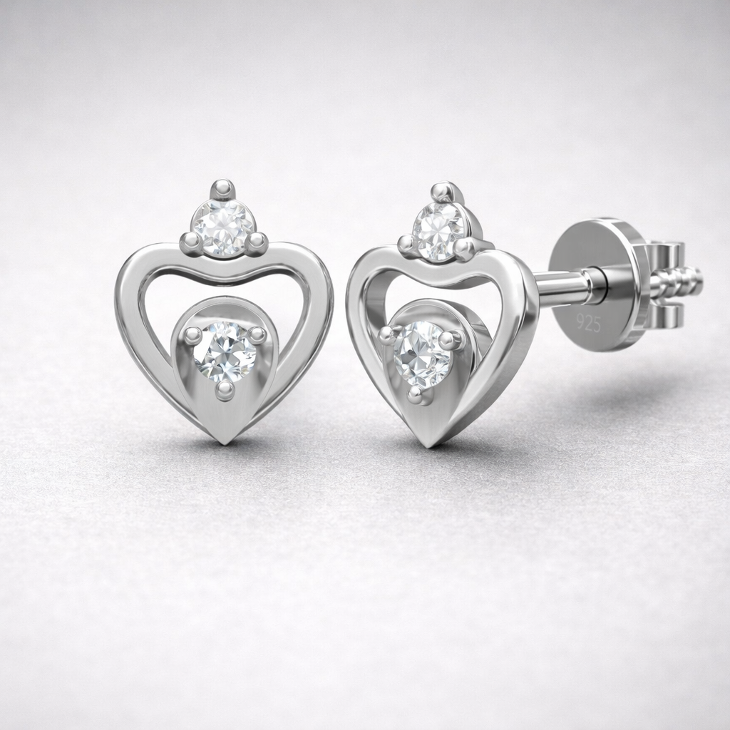 Heart-shaped silver earrings with clear gemstones on a light gray background