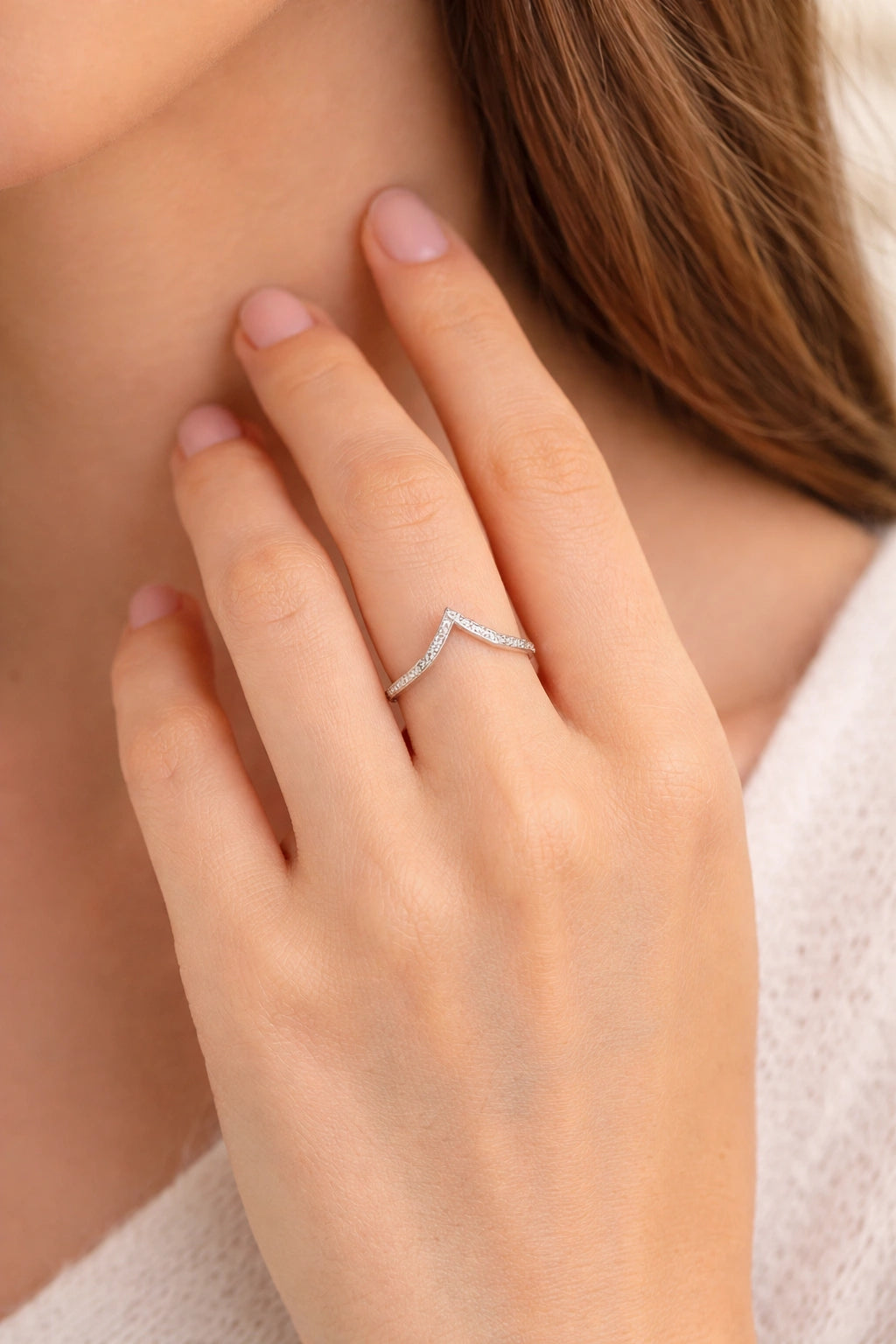 Close-up of a hand wearing a diamond ring with a soft focus background