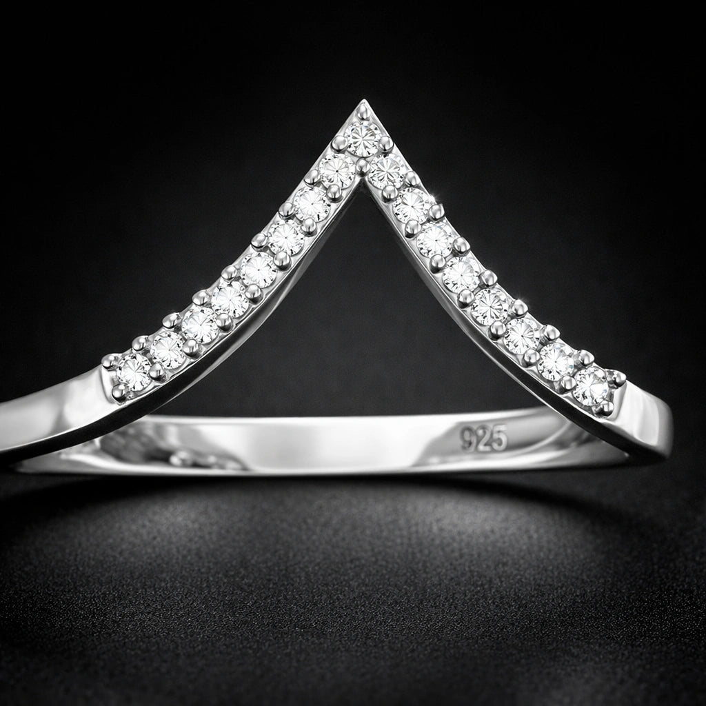 Silver triangle-shaped ring with embedded stones on a dark background