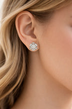 Close-up of a diamond earring worn by a person with blonde hair.