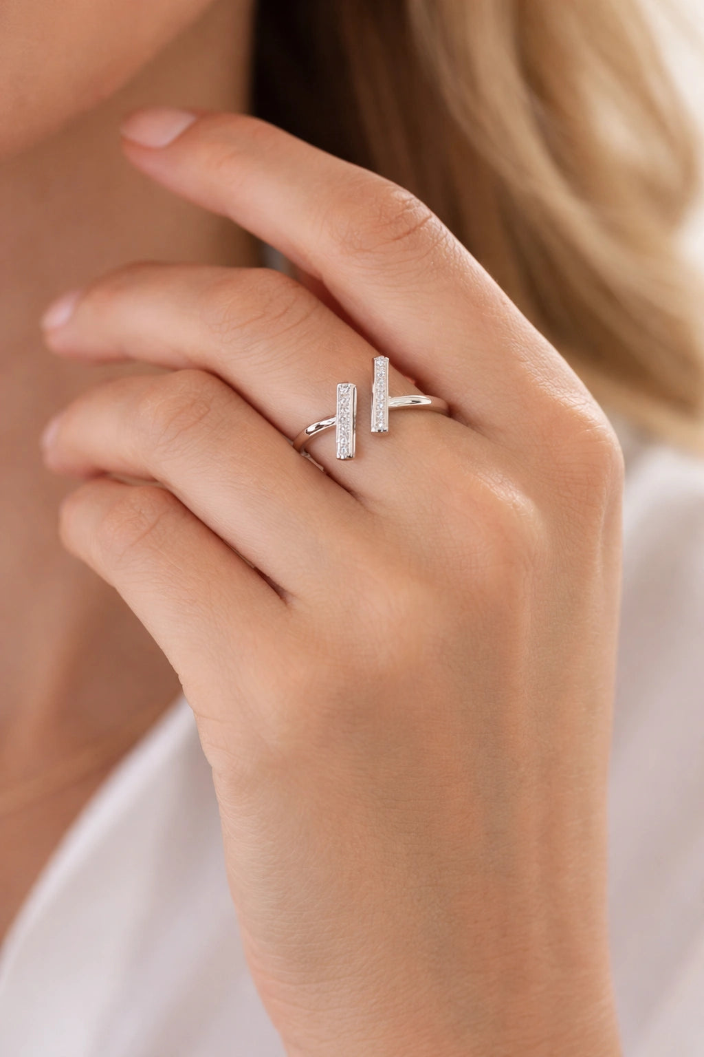 Close-up of a hand wearing a silver ring with a diamond design.
