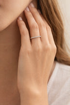 Close-up of a hand wearing a silver ring with a blurred background