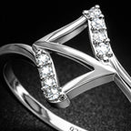 Silver ring with diamond accents on a dark background