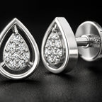 Silver teardrop-shaped earrings with clear gemstones on a dark background