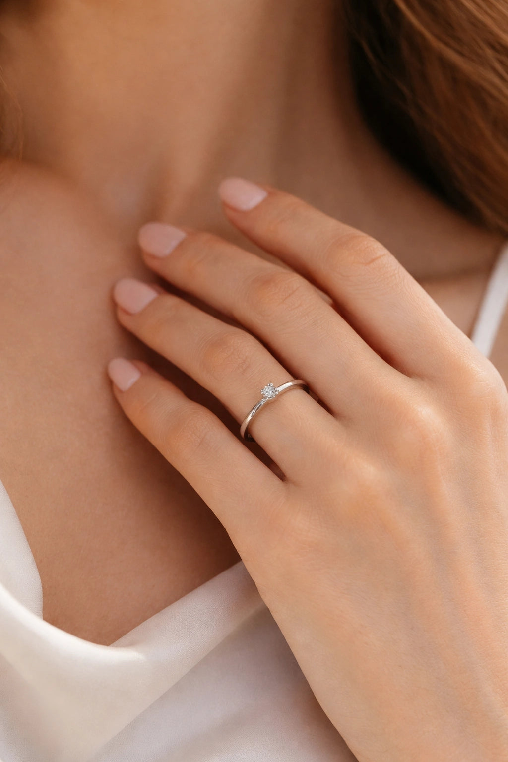 Close-up of a hand wearing a diamond ring on a blurred background