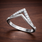 Silver ring with diamond accents on a wooden surface