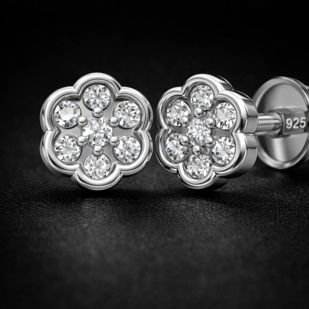 Silver flower-shaped earrings with clear gemstones on a dark background