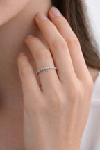Close-up of a hand wearing a silver ring with a blurred background