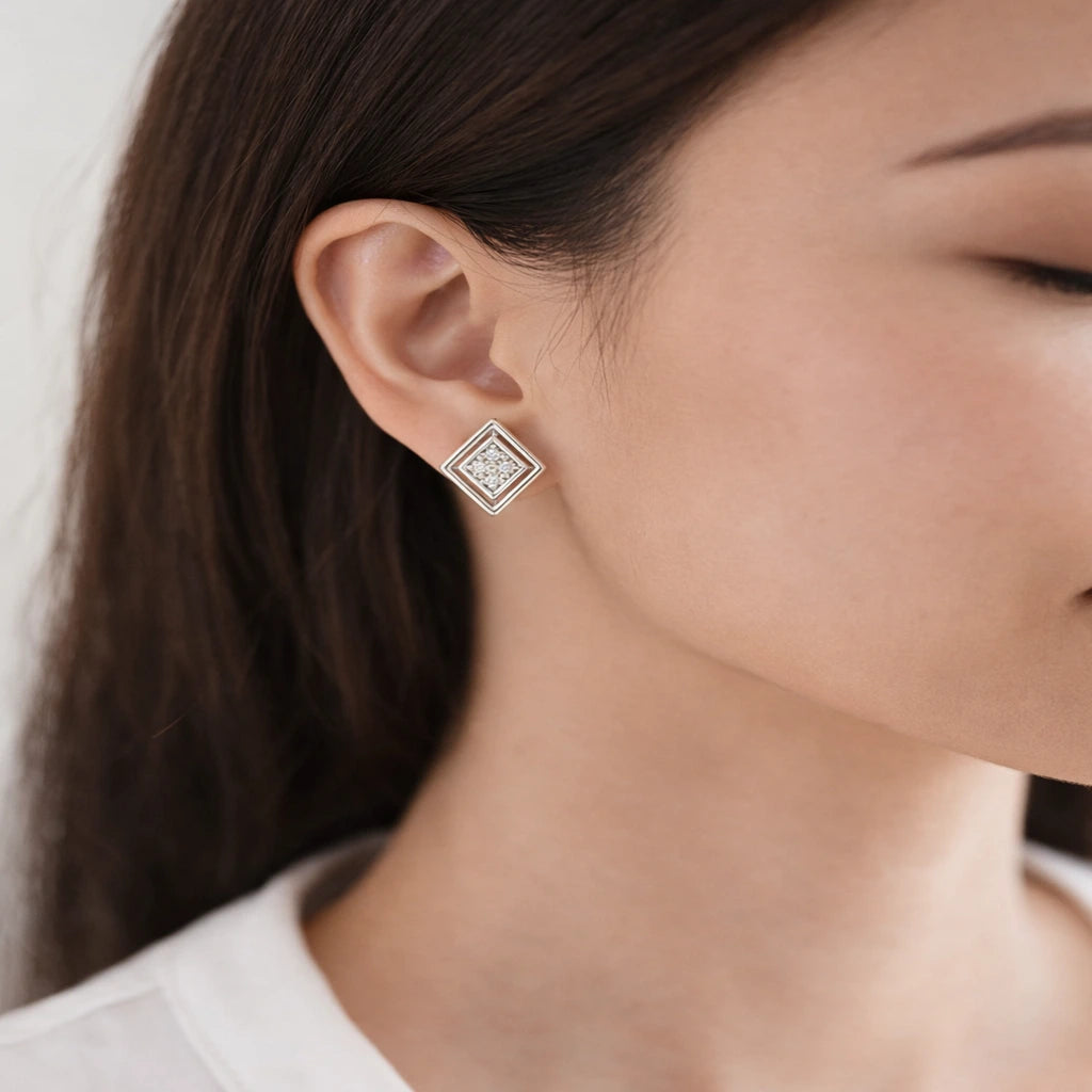 Close-up of a person wearing a diamond stud earring.