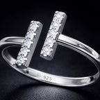 Silver ring with diamond accents on a dark background