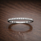 Silver ring with small diamonds on a wooden surface