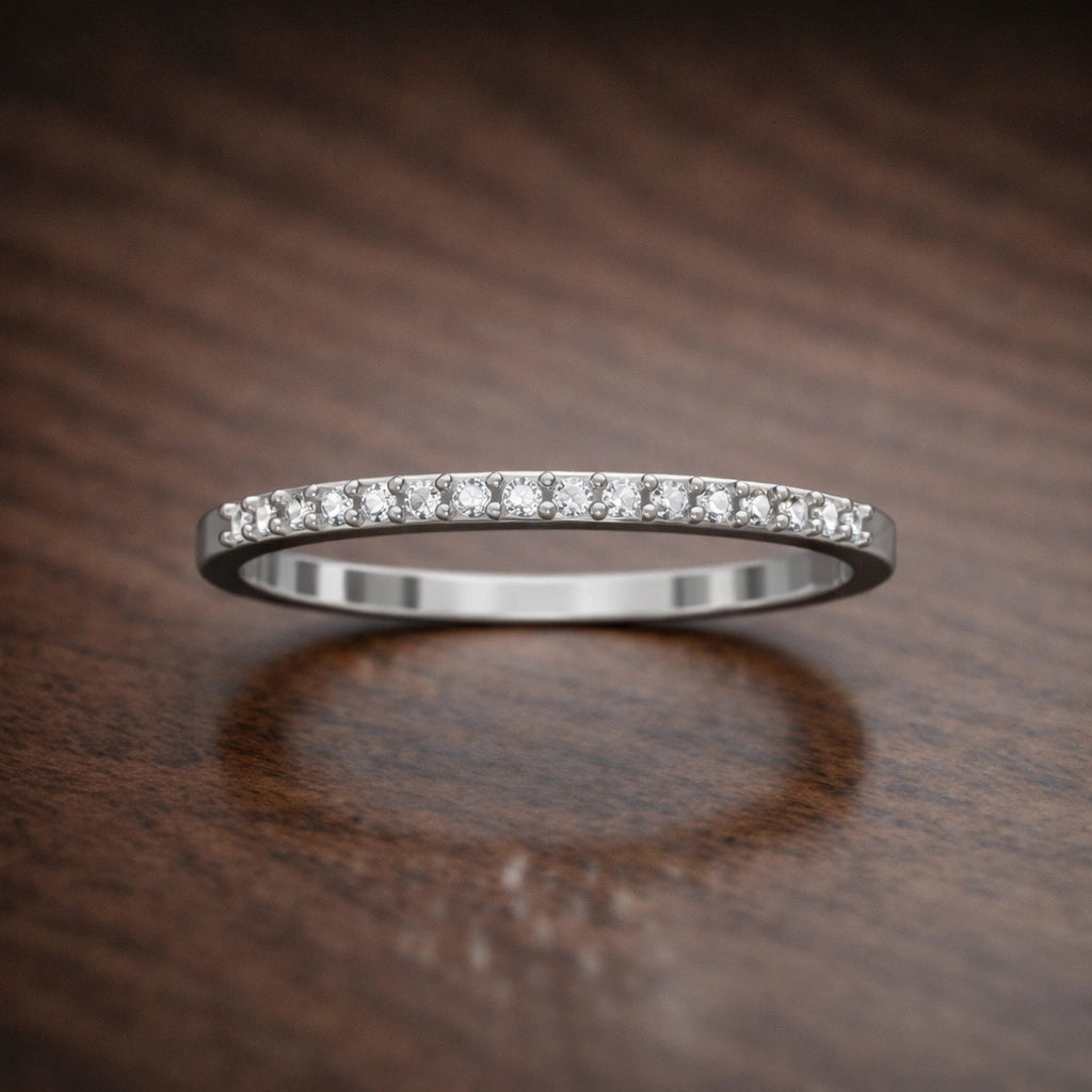 Silver ring with small diamonds on a wooden surface