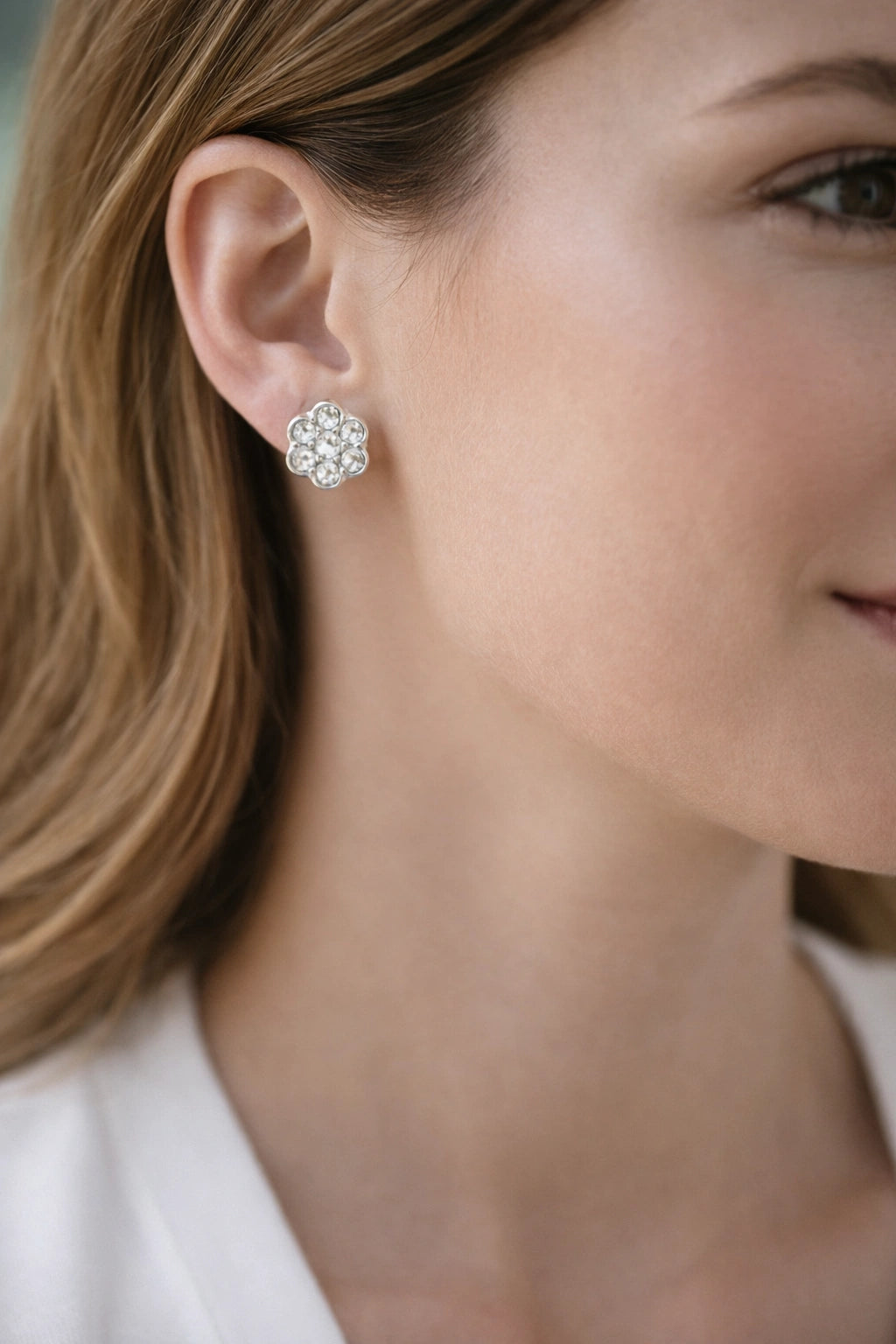 Close-up of a woman wearing silver earrings with a blurred background
