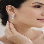 Close-up of a woman wearing a silver earring with a hand adjusting it.