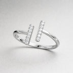 Silver ring with diamond accents on a light gray background