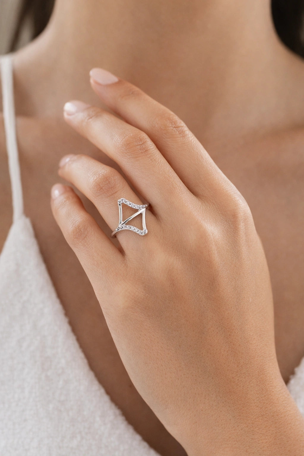 Close-up of a hand wearing a diamond ring with a triangle design.