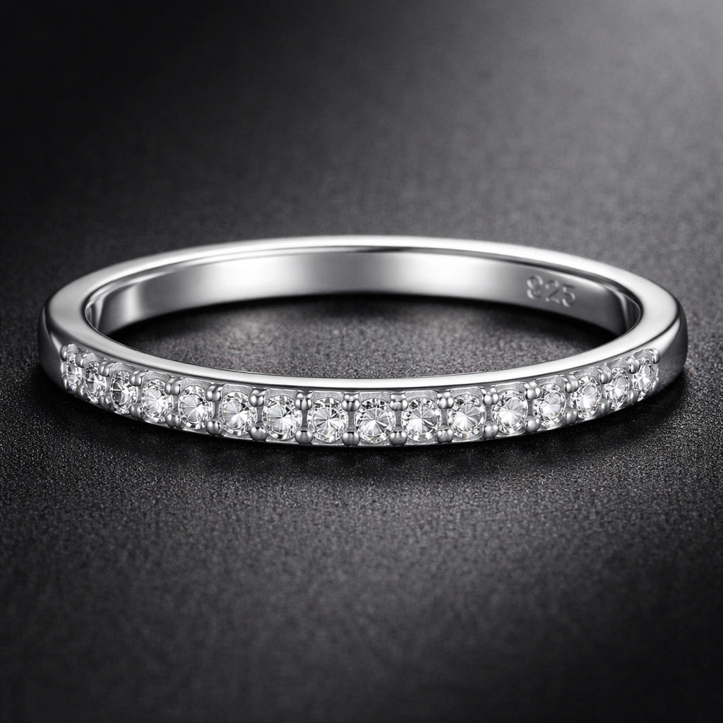 Silver ring with small diamonds on a dark background