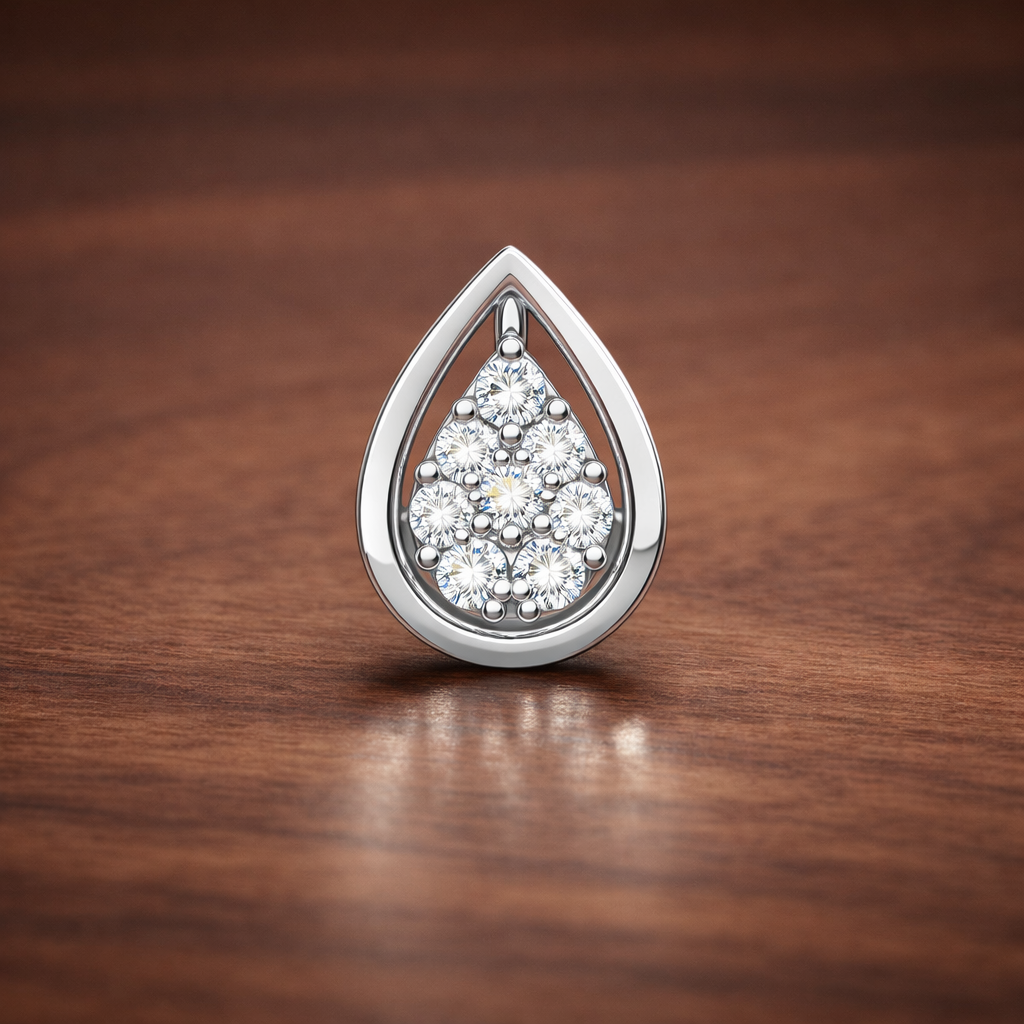 Teardrop-shaped silver pendant with clear stones on a wooden surface