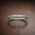 Silver ring with diamonds on a brown textured surface