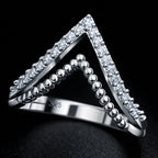 Silver triangle-shaped ring with embedded stones on a black background
