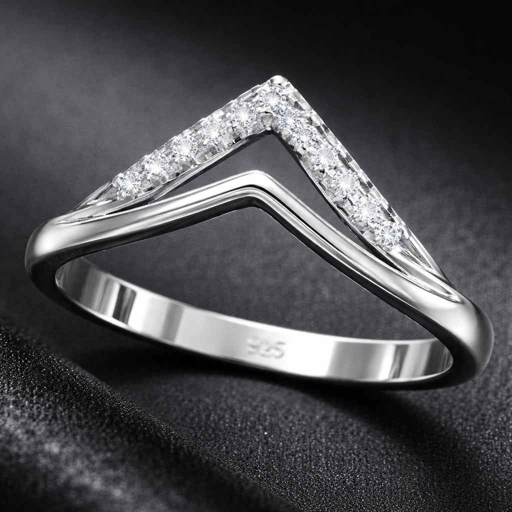 Silver ring with diamond accents on a dark background