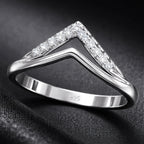 Silver ring with diamond accents on a dark background