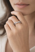 Close-up of a hand wearing two silver rings with a soft background