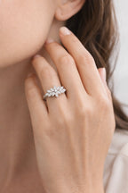 Close-up of a hand wearing a diamond ring with a blurred background