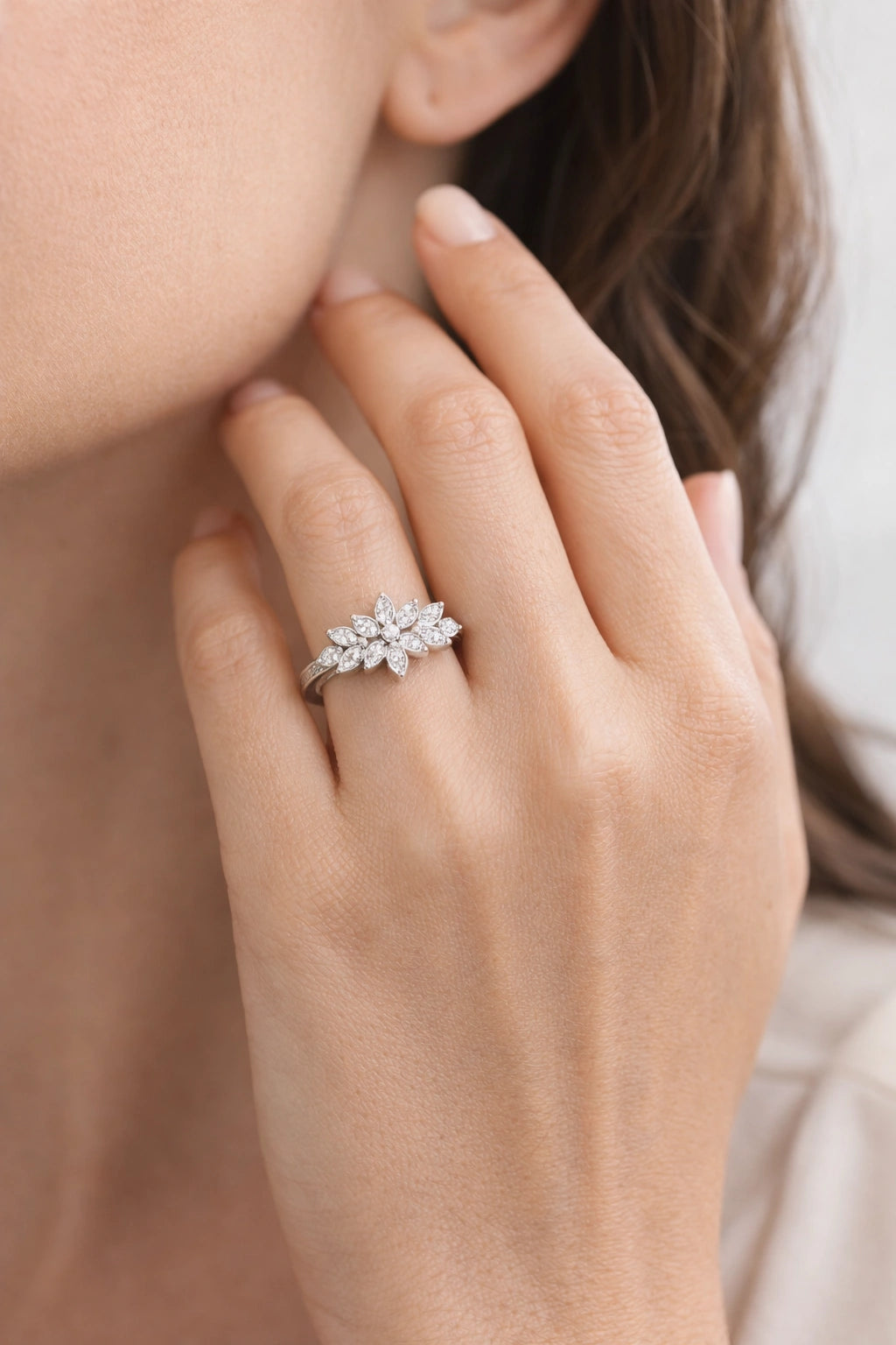 Close-up of a hand wearing a diamond ring with a blurred background